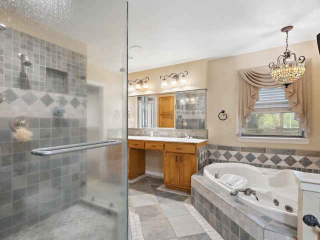 bathroom with a shower stall, vanity, a whirlpool tub, a notable chandelier, and tile patterned flooring