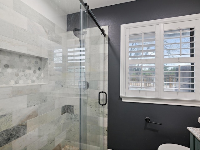 bathroom featuring toilet and a shower stall