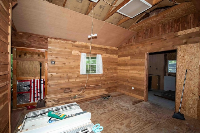 interior space featuring vaulted ceiling and wood walls