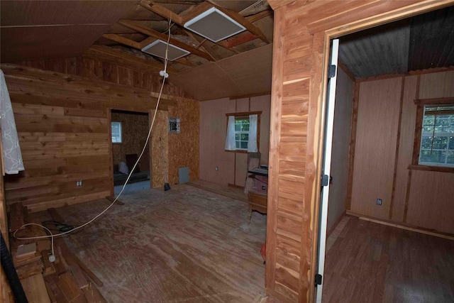 interior space with lofted ceiling, wooden walls, wood finished floors, and a wealth of natural light
