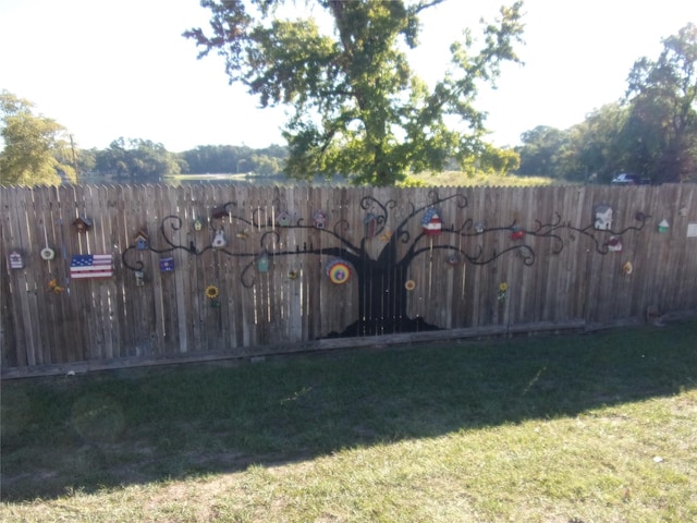 view of gate featuring fence and a yard