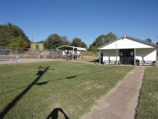 view of yard with fence, a carport, and a fenced in pool