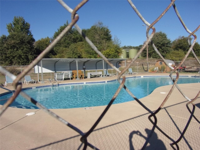 community pool featuring a water slide and a patio