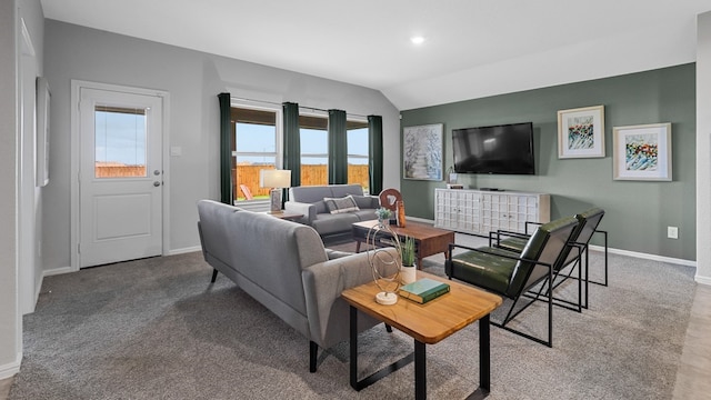 living area featuring lofted ceiling and baseboards