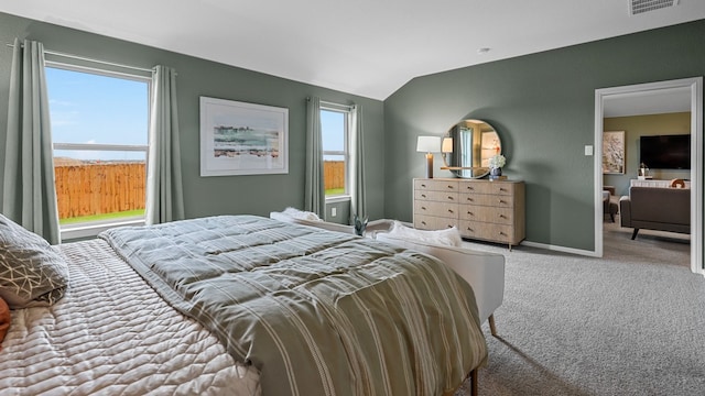carpeted bedroom with baseboards, vaulted ceiling, and visible vents