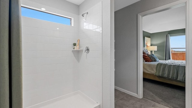bathroom featuring baseboards, tile patterned flooring, tiled shower, and ensuite bathroom