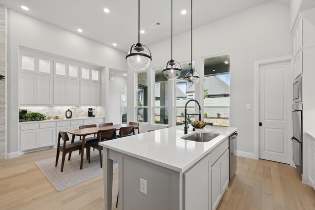 1808 Wren St, Argyle, TX 76226 - kitchen with a sink, light wood-type flooring, appliances with stainless steel finishes, a center island with sink, and light countertops