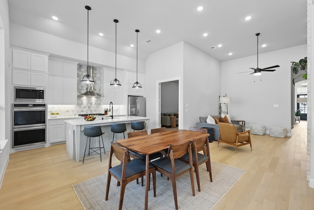 1808 Wren St, Argyle, TX 76226 - dining area featuring light wood-style flooring, ceiling fan, recessed lighting, and a towering ceiling