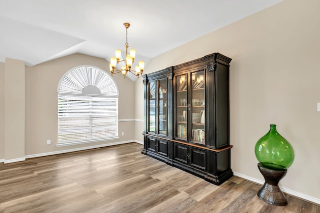 8405 Evening Star Dr, Rowlett, TX 75089 - dining room featuring a chandelier, lofted ceiling, light wood finished floors, and baseboards