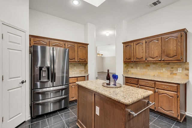 8405 Evening Star Dr, Rowlett, TX 75089 - kitchen featuring stainless steel fridge with ice dispenser, a kitchen island, backsplash, light stone counters, and recessed lighting