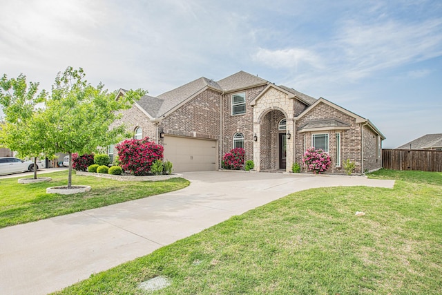 view of front of house with brick siding, driveway, a front yard, and fence