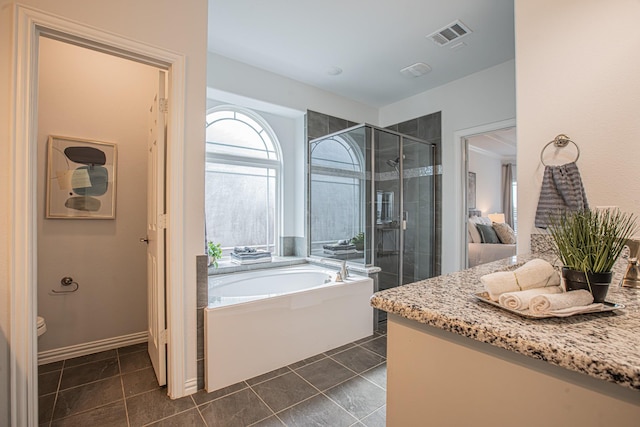 ensuite bathroom featuring tile patterned floors, visible vents, toilet, a garden tub, and a stall shower
