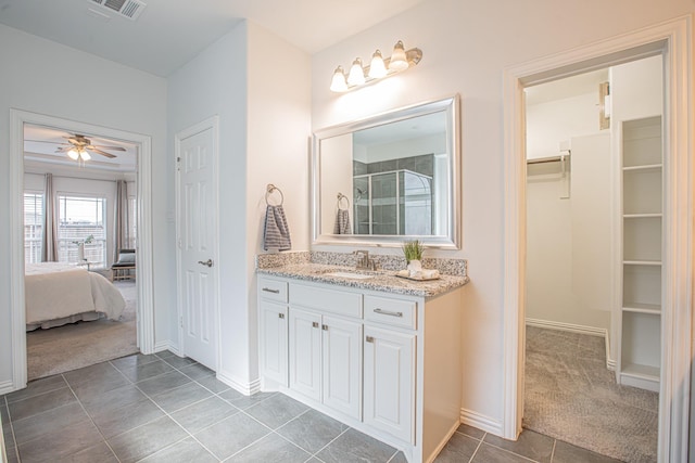 full bath with a spacious closet, visible vents, vanity, a stall shower, and ceiling fan