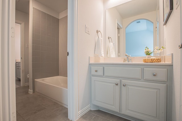 bathroom with bathtub / shower combination, baseboards, and vanity