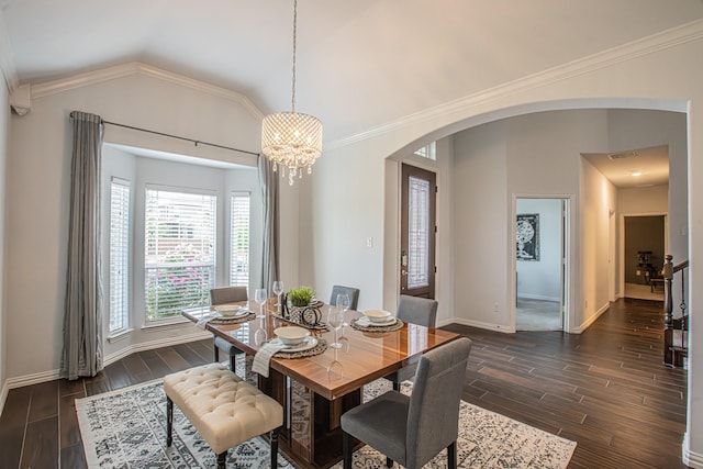 dining space with baseboards, vaulted ceiling, wood finish floors, and arched walkways