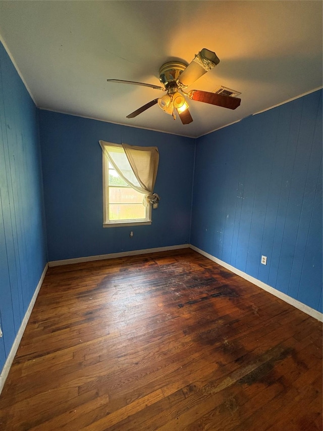 215 Fair Park St, Riesel, TX 76682 - unfurnished room featuring hardwood / wood-style floors, ceiling fan, wooden walls, and baseboards