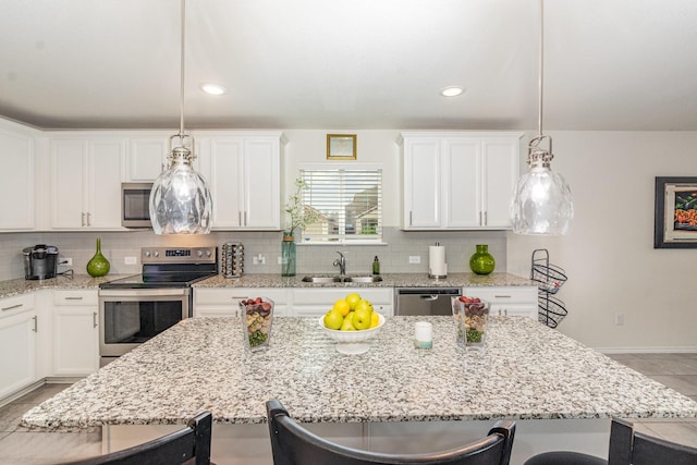 kitchen featuring stainless steel appliances, a kitchen breakfast bar, a sink, and backsplash