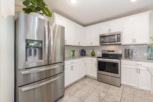 kitchen with white cabinets, tasteful backsplash, and appliances with stainless steel finishes