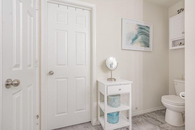 bathroom featuring toilet and baseboards