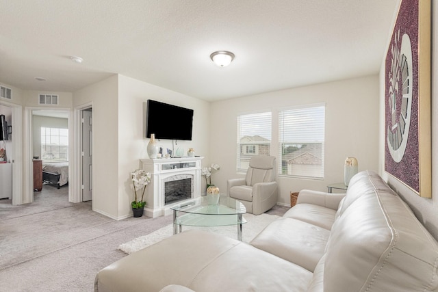 living area with a high end fireplace, baseboards, carpet flooring, and visible vents