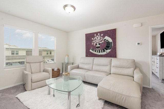carpeted living area with baseboards