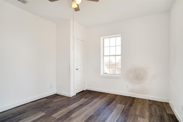 empty room with ceiling fan, baseboards, wood finished floors, and visible vents