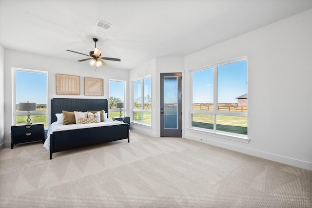 bedroom featuring visible vents, light carpet, baseboards, and access to exterior