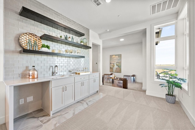 bar featuring wet bar, visible vents, decorative backsplash, and a sink