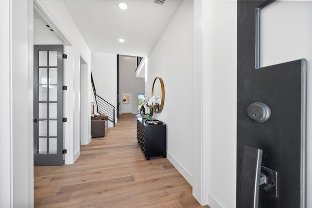 hallway featuring recessed lighting, visible vents, light wood-style floors, baseboards, and stairs