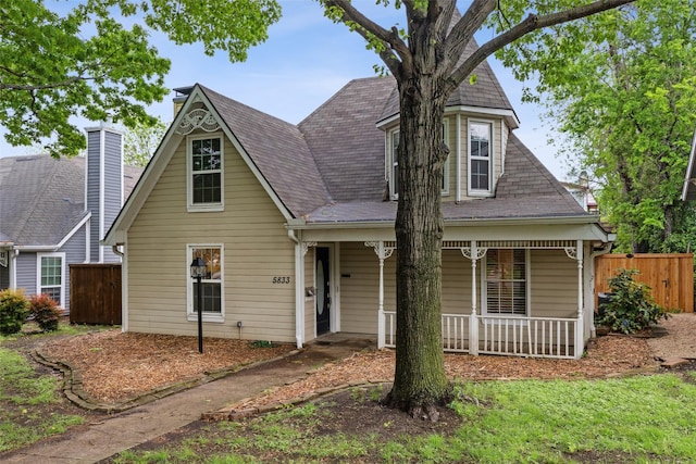 view of front of property featuring fence and covered porch