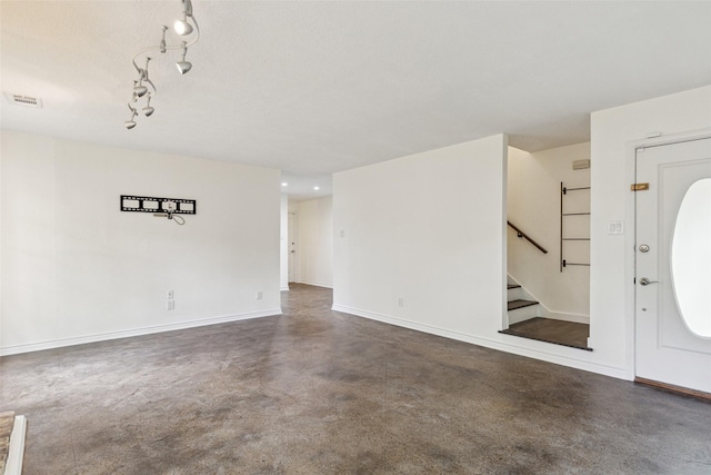 foyer entrance with visible vents, baseboards, concrete flooring, and stairs