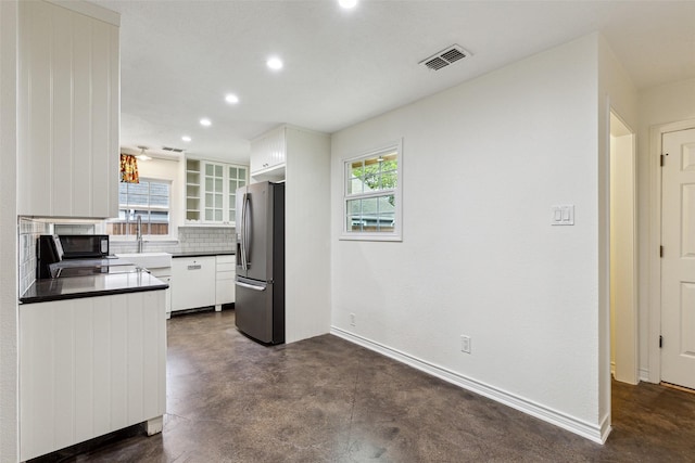 kitchen featuring white cabinetry, stainless steel fridge with ice dispenser, dark countertops, and visible vents