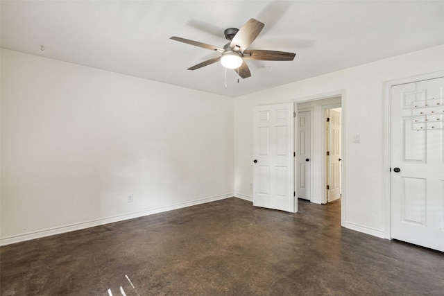 unfurnished bedroom featuring ceiling fan, concrete floors, and baseboards