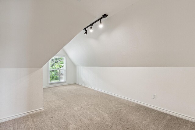 bonus room with lofted ceiling, baseboards, and carpet floors