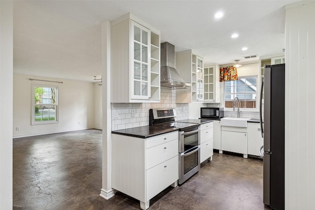 kitchen featuring wall chimney range hood, appliances with stainless steel finishes, finished concrete floors, and a sink