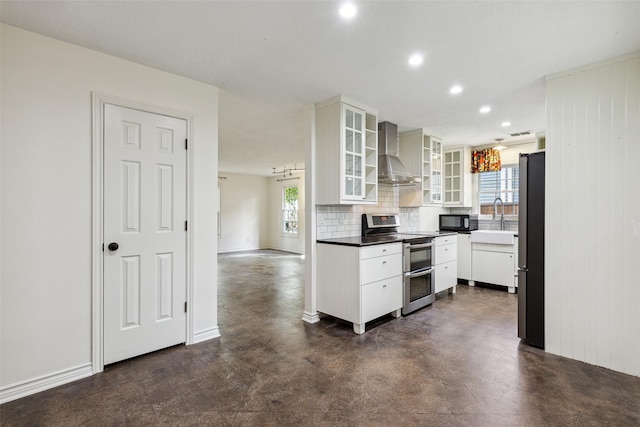 kitchen with wall chimney exhaust hood, finished concrete flooring, stainless steel appliances, and a healthy amount of sunlight