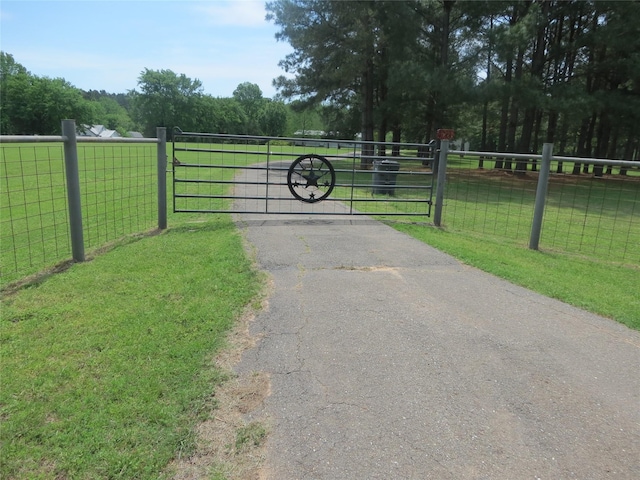 view of gate with a yard and fence