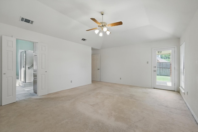 interior space with lofted ceiling, visible vents, light colored carpet, and ceiling fan