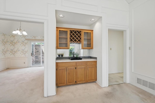 bar featuring a wainscoted wall, an inviting chandelier, visible vents, light carpet, and a decorative wall