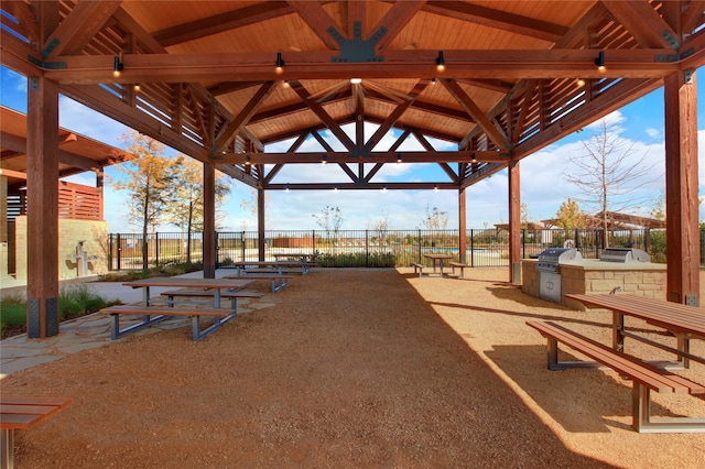 surrounding community with a gazebo, fence, and area for grilling
