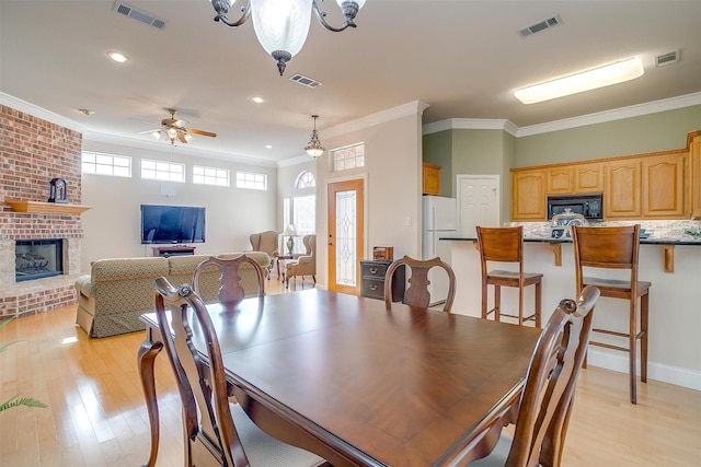 11632 Virginia Way Ct, Fort Worth, TX 76008 - dining space with a brick fireplace, visible vents, and light wood finished floors
