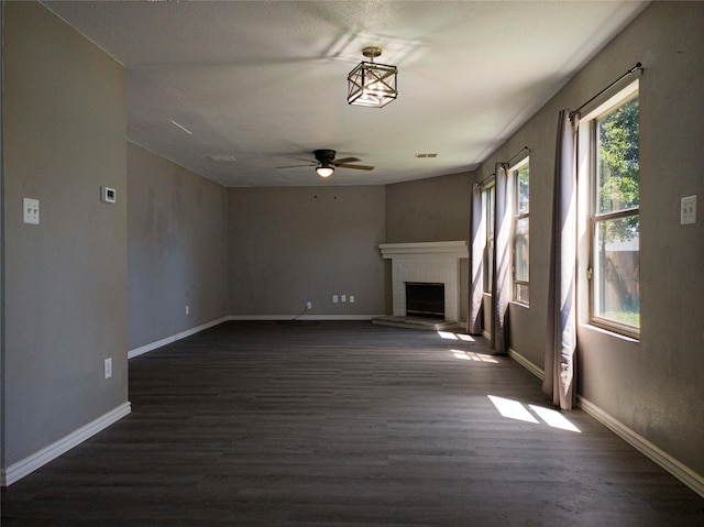 920 Kendall Dr, Arlington, TX 76001 - unfurnished living room featuring ceiling fan, dark wood finished floors, a brick fireplace, and baseboards