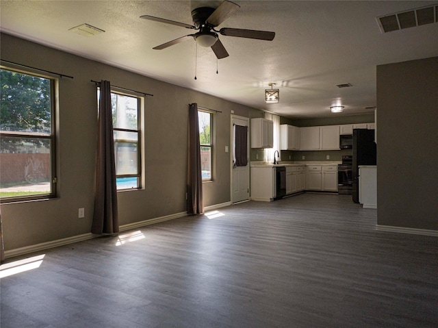 920 Kendall Dr, Arlington, TX 76001 - kitchen featuring black dishwasher, freestanding refrigerator, dark wood finished floors, ceiling fan, and white cabinetry