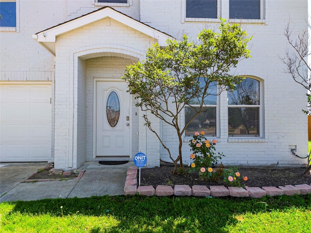 920 Kendall Dr, Arlington, TX 76001 - view of exterior entry featuring brick siding and an attached garage