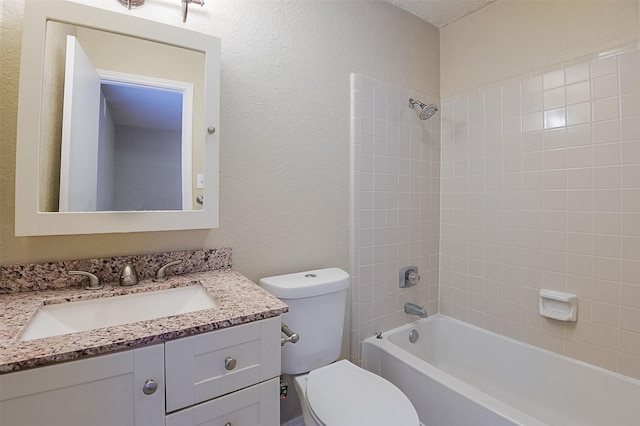 full bathroom featuring a textured wall, toilet, vanity, and bathtub / shower combination