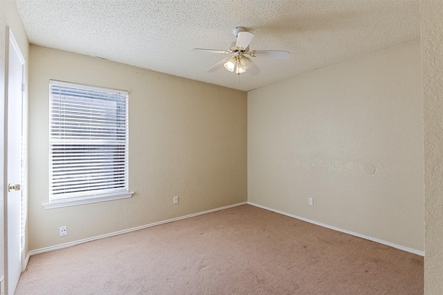 empty room featuring a wealth of natural light, carpet floors, a textured ceiling, and ceiling fan