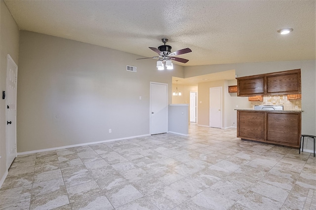 unfurnished living room with baseboards, a ceiling fan, and visible vents