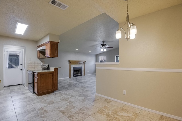 kitchen with electric range, brown cabinetry, a textured ceiling, and visible vents