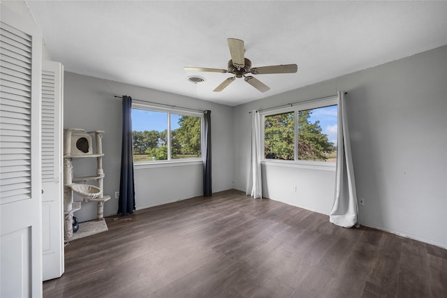 unfurnished bedroom with wood finished floors, visible vents, a ceiling fan, and baseboards