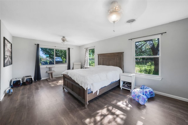 bedroom with visible vents, baseboards, and dark wood-style flooring